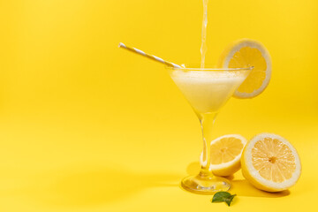 Fresh lemonade with lemon on yellow background