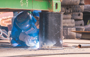 Welder is welding metal bollard to use for support foundation of the old container that have been renovated to outdoor office or storage room