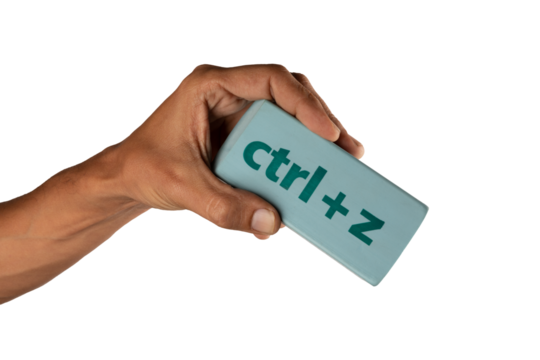 black male Hand holding an eraser with inscription ctrl z on white background