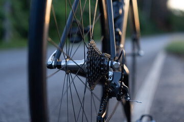 Road bike parked on a beautiful road sunset, warm light with copy space.	