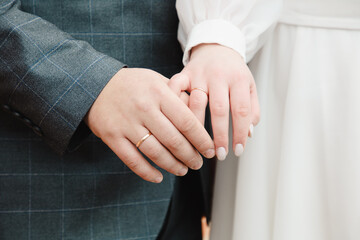 Bride and groom holding hands, close-up