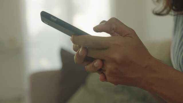 Side view. Hand of Asian woman using texting mobile phone or chat. Close- up business women hand