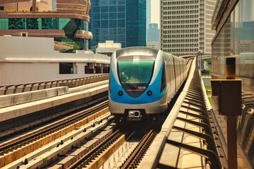Train on railway of Dubai subway at glass urban skyscrapers backdrop in business district. Wallpaper of metropolitan city metro in desert arabic country. Public transport concept. Copy ad text space