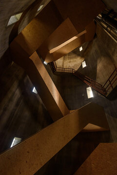 Abstract Image Upward Of A Wooden Spiral Staircase In A Concrete Tube With Natural Incident Light