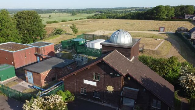 Aerial view Pex hill Leighton observatory silver dome rooftop on hilltop farmland at sunrise, slow reverse reveal left