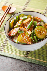 Oi muchim is a Korean spicy cucumber salad closeup on the bowl on the table. Vertical