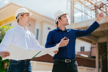 A team of Asian engineers, 2 people are the technician managers. point to destination use blueprint In design, construction, architecture industry use radio communication Wear helmets and uniforms.