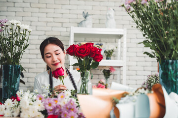 Beautiful florist is meticulously trimming the flowers to arrange flowers in a vase for display in a flower shop.