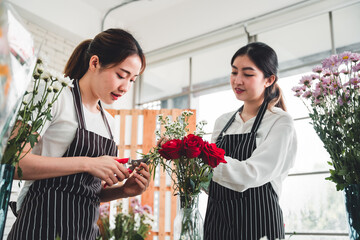 Two beautiful florist meticulously arrange flowers in a vase for customers in the flower shop.