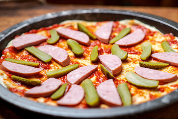 Pickled cucumbers laid out on a pizza crust covered with tomato sauce. Cooking pizza with pickled cucumbers.