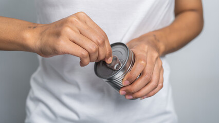 Hand holds canned food isolated on white, woman hands.