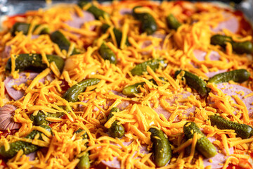 Raw pizza with pickles and cheese. Cooking homemade pizza.