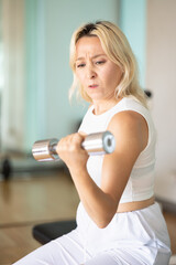 Fototapeta na wymiar Serious and disciplined fitness woman working out in temperature controlled indoor gym