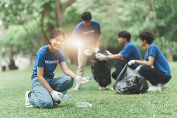 Fototapeta premium Young Asian Volunteers with garbage bags cleaning park area. Ecology, Charitable organization concept
