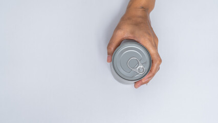 Hand holds canned food isolated on white, woman hands.