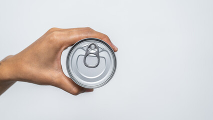 Hand holds canned food isolated on white, woman hands.