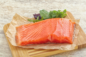 Raw salmon fillet over board