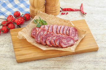 Sliced salami sausages over board