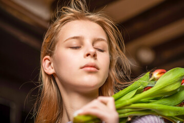 Naklejka premium Portrait of a young girl with closed eyes on a dark background.