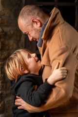 A man embraces his young son. Father's Day, the long-awaited meeting. A middle-aged man and a nine-year-old boy.