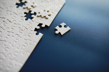 Clean puzzle elements on the background. Empty puzzle piece on the table. Teamwork concept. - Powered by Adobe