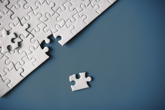 Clean puzzle elements on the red background. Empty puzzle piece on the table. Teamwork concept.