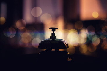 Vintage bell stands on wooden counter to attract attention