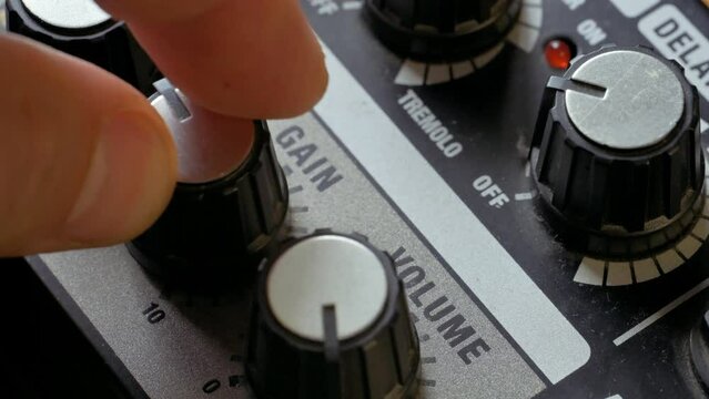 Man tuning gain knob on guitar amplifier. 4k video footage UHD 3840x2160