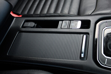 Leather car interior. Car armrest with storage box. Electronic handbrake in car. Handbrake button. Armrest with Seat Adjustment Buttons. Lux car interior with carbon fiber trims.
