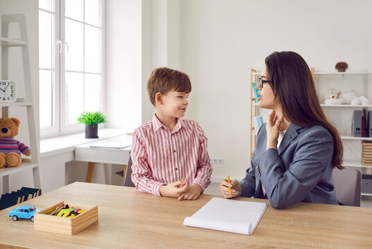 Child learning correct pronunciation with speech therapist. Woman language pathologist helps little boy articulate sounds or get rid of his stammering, stuttering impediment. Speech therapy concept