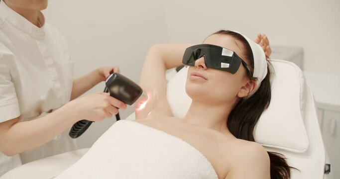 Hardware removal of hair on the legs in a beauty salon. Laser epilation cosmetology. hair removal procedure, Laser epilation. Laser hair removal of armpit in modern cosmetology clinic,
