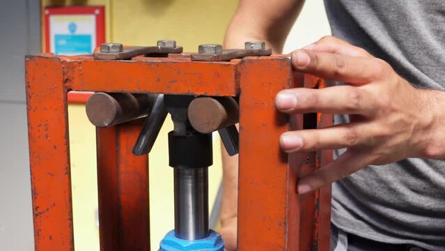 Slow motion shot of a metal bar bending clamp being operated by an engineering student. Filmed in an industry workshop in Stornoway on the Isle of Lewis, part of the Outer Hebrides of Scotland.