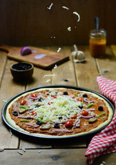 Flying pizza , Vegetables and salami pizza on a wooden table, with mozzarella cheese, food photography .