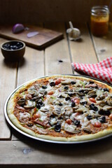 Vegetable and salami pizza on a wooden table , with mozzarella cheese.  food photography .