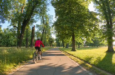 attractive senior woman cycling with her electric mountain bike in the city park of Stuttgart,...