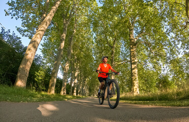 attractive senior woman cycling with her electric mountain bike in the city park of Stuttgart, Baden-Wuerttemberg, Germany