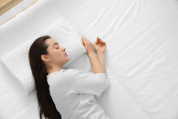 Woman sleeping on memory foam pillow, top view. Space for text