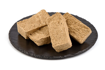 Pieces of sunflower halva, isolated on white background.