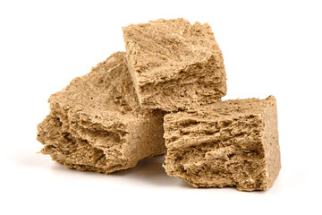 Pieces of sunflower halva, isolated on white background.