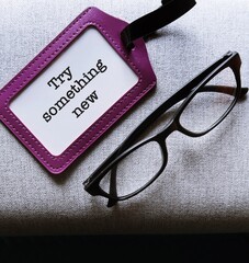 reading glasses and ID card holder black copy space background with text TRY SOMETHING NEW, to...