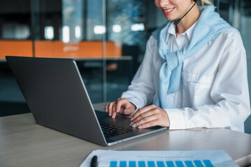 Young woman working at the office and typing on a laptop