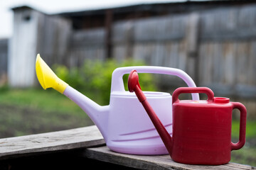 watering cans for watering the earth, pink and red watering can