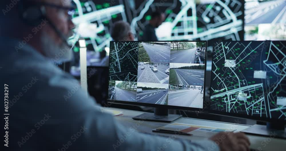 Poster Technical Customer Support Specialist is Talking on a Headset while Working on a Computer in a Call Center Control Room Filled Display Screens with Monitoring Software. Over the Shoulder Footage