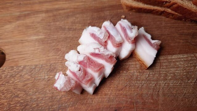 Slices of salted pork fatback on cutting board, close-up