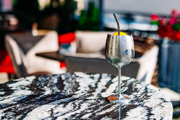 alcoholic cocktail in a metal glass stands on a table in a bar or restaurant