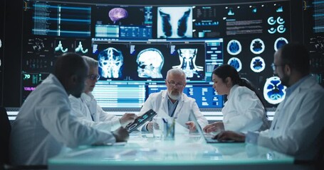 Chief Doctor Conducting a Pre-Operative Assessment Meeting With His Surgical Team. Group of Brain Surgeons Discussing Possible Treatment in an Advanced Laboratory with Interactive Digital Screens - Powered by Adobe
