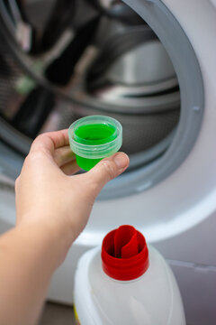Washing machine laundry full plastic cap of green liquid detergent