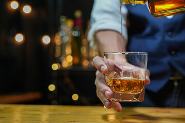 Bartender pouring Whiskey, on  bar - obrazy, fototapety, plakaty