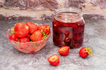 Homemade delicious strawberry jam and strawberry on a rustic wooden table