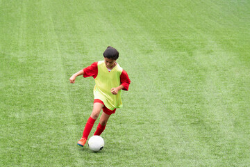 teenage girl playing soccer in the stadium